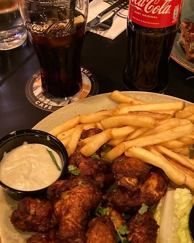 Alitas con papas fritas, salsa y Coca-Cola